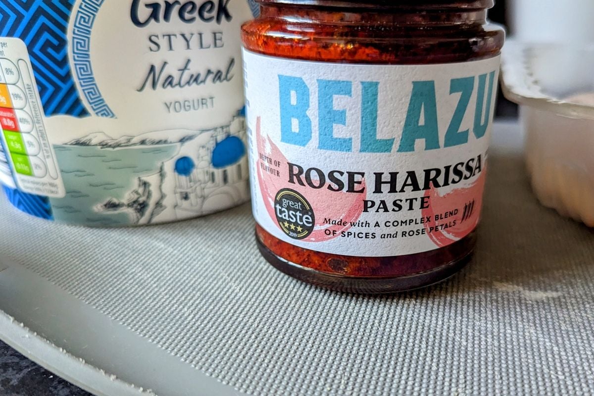 Harrissa pesto and yogurt pot on a blue chopping board