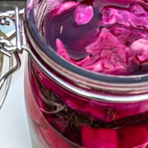 Pink sauerkraut in a glass jar with attached glass lid