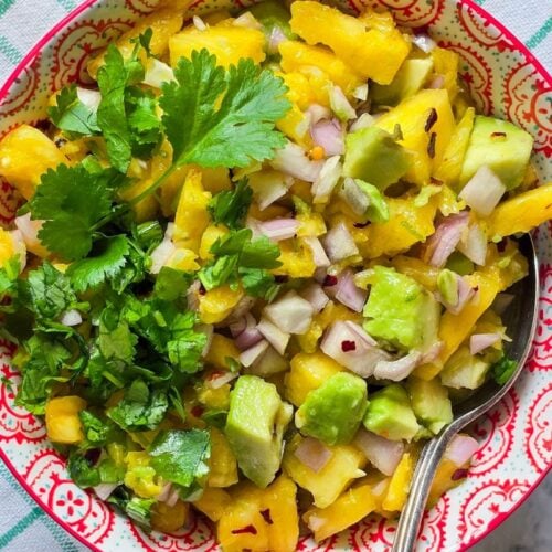 OFresh avocado pineapple salsa with pineapple, avocado, lime, shallot, herbs, and chili flakes.