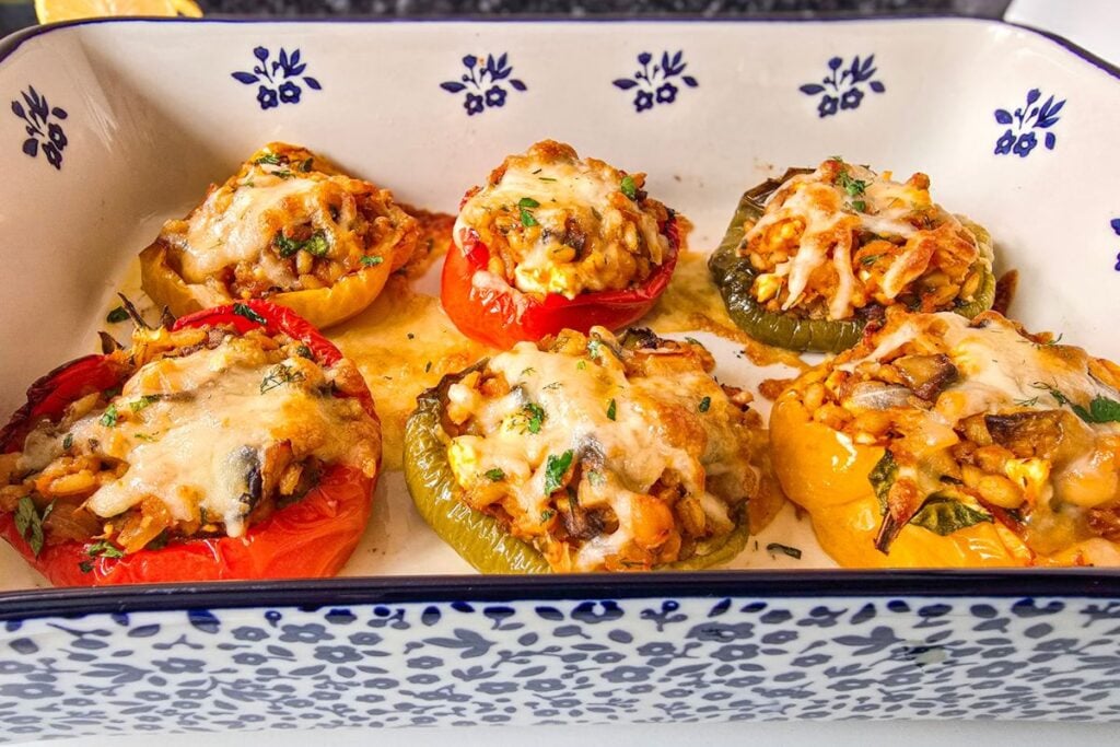 baked barley stuffed peppers with chickpeas and feta, cheese melted and golden on top.