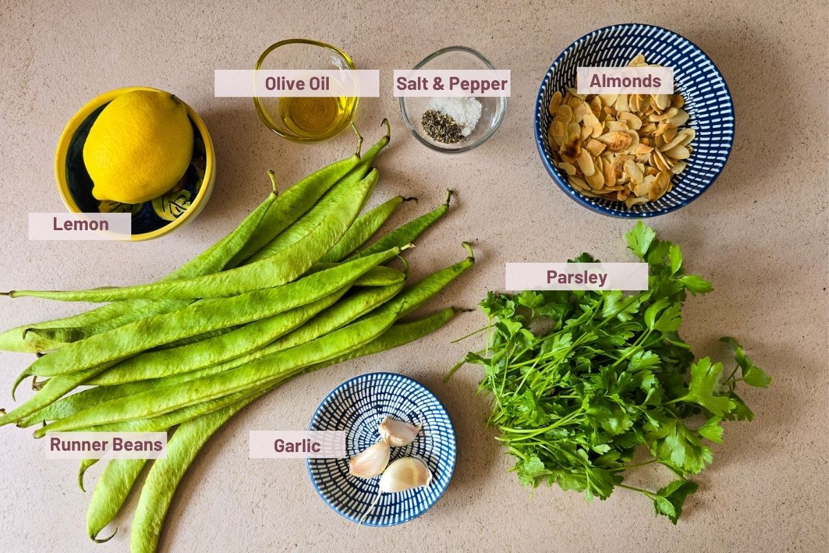 Runner bean salad ingredients: fresh runner beans, parsley, garlic, lemon, olive oil, and flaked almonds