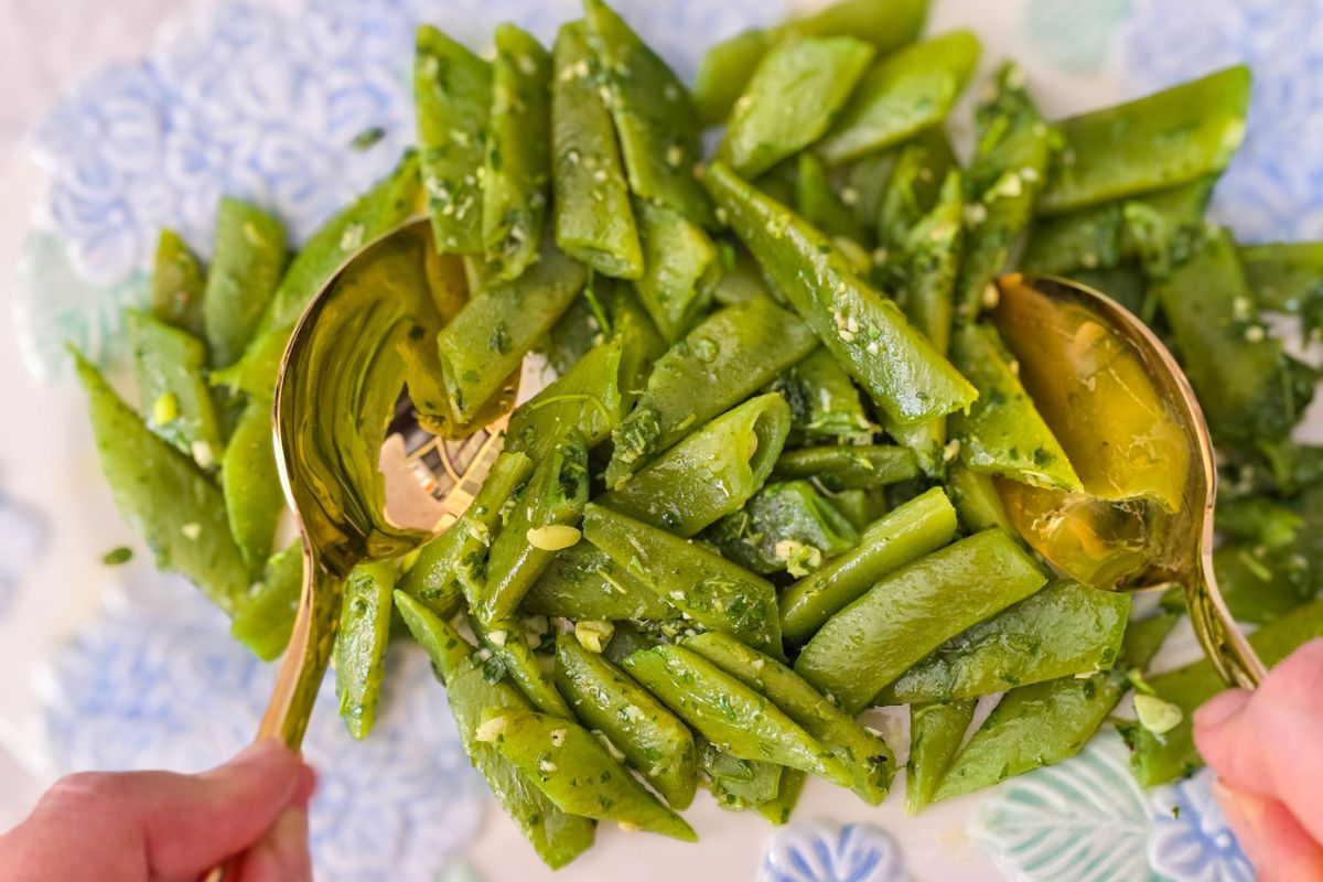 Tossing runner bean salad with gremolata using gold serving spoons
